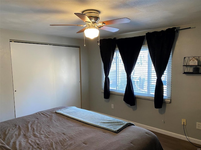 unfurnished bedroom with hardwood / wood-style flooring, ceiling fan, and a closet