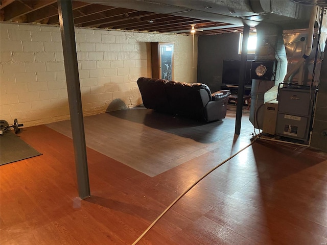 basement featuring heating unit and hardwood / wood-style flooring