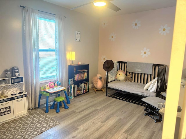 bedroom with light hardwood / wood-style flooring and ceiling fan