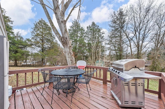 wooden deck with outdoor dining space and grilling area