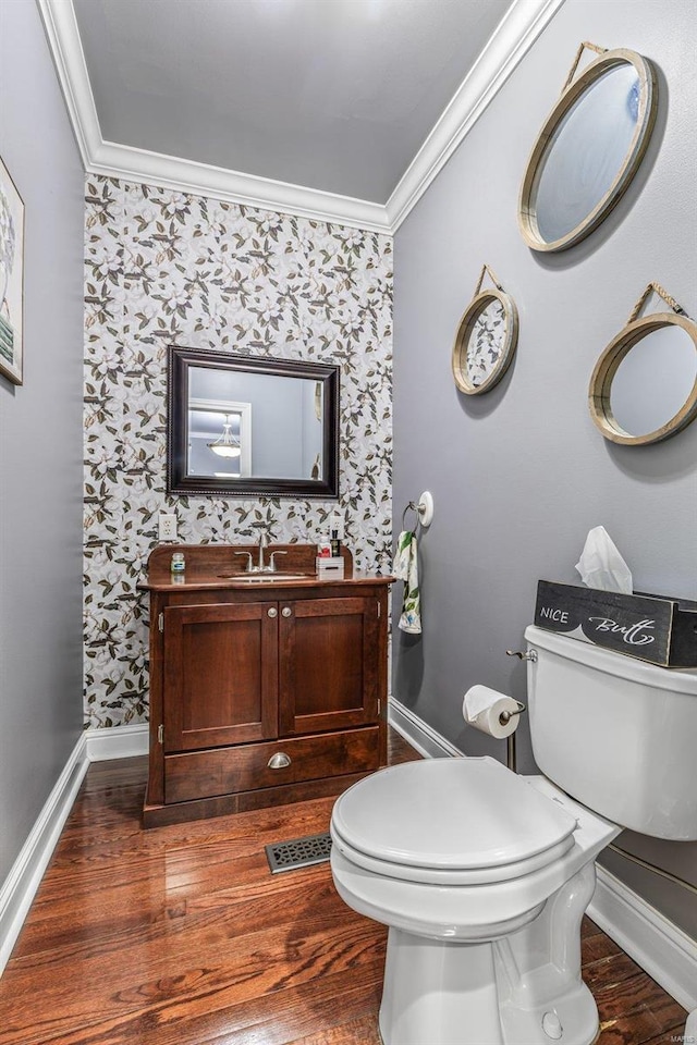 bathroom with ornamental molding, toilet, hardwood / wood-style floors, and vanity