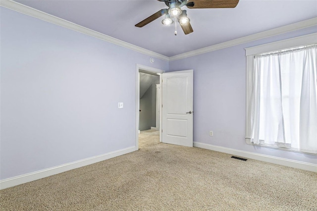 unfurnished room featuring crown molding, light colored carpet, and ceiling fan