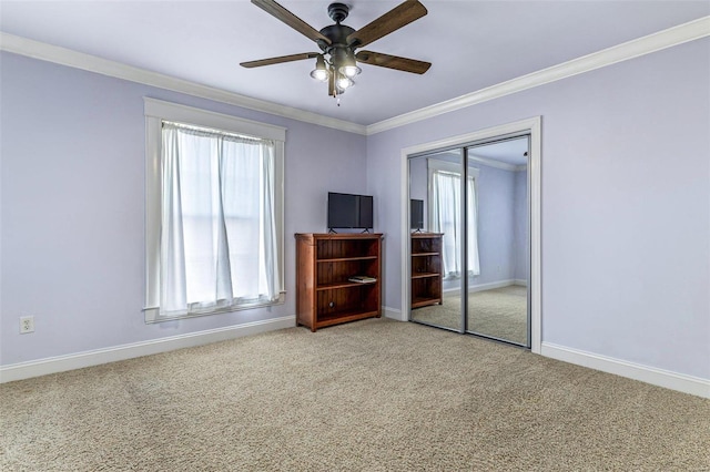 unfurnished bedroom with multiple windows, crown molding, carpet flooring, and a closet