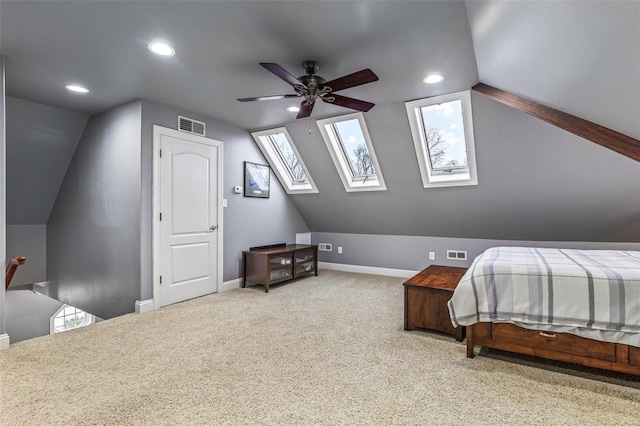 carpeted bedroom featuring lofted ceiling with skylight and ceiling fan