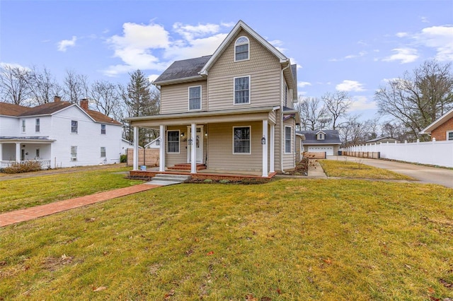 view of front of home featuring a porch, a garage, and a front yard