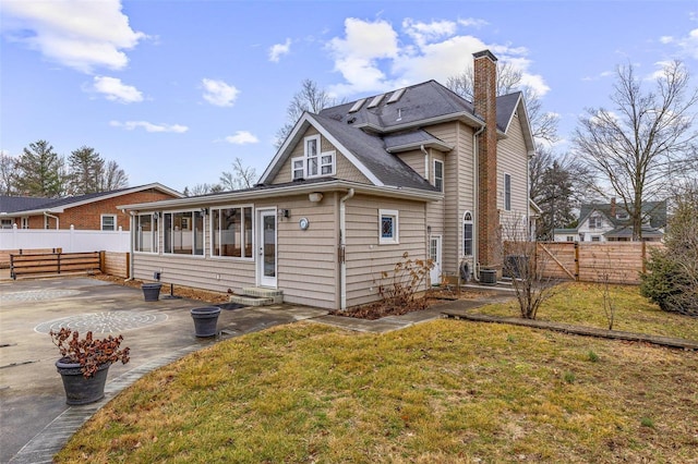 back of house featuring central AC, a patio area, and a lawn