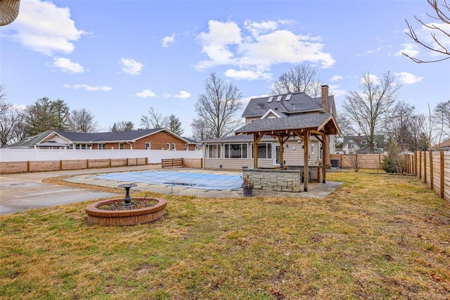 view of yard with a patio area, a sunroom, and a covered pool