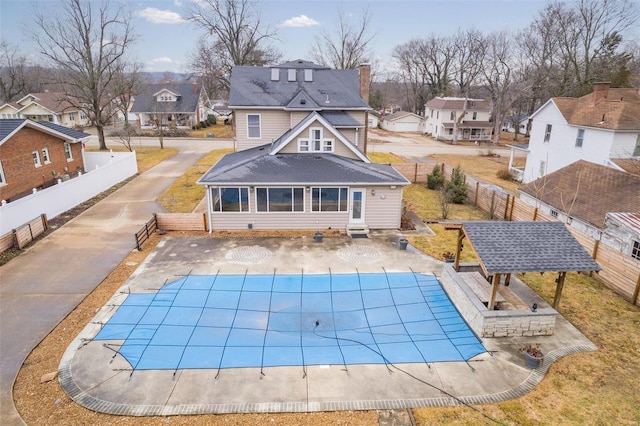 back of property featuring a patio area and a covered pool