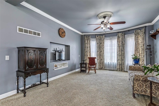 living area featuring crown molding, carpet floors, and ceiling fan