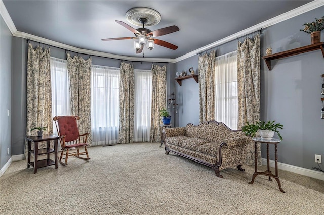 living area with crown molding, ceiling fan, and carpet