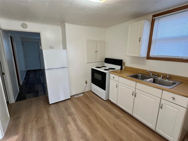 kitchen featuring white refrigerator, white cabinetry, sink, and electric range oven