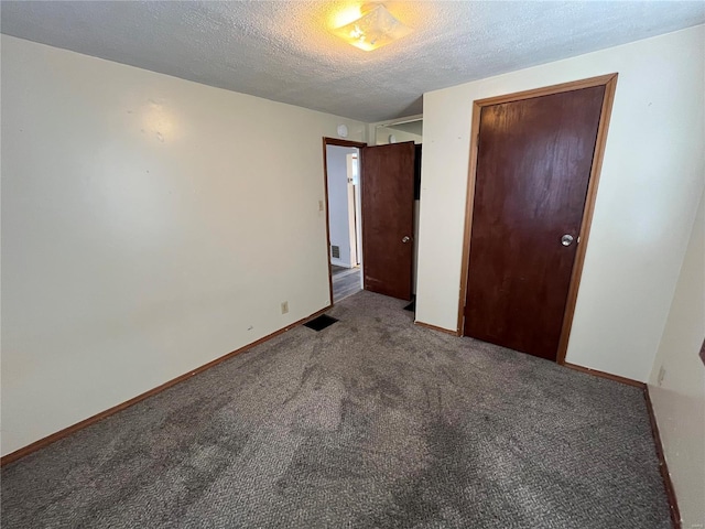 unfurnished bedroom featuring a closet, carpet flooring, and a textured ceiling