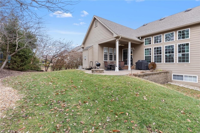 rear view of property featuring a yard, ceiling fan, and a patio area