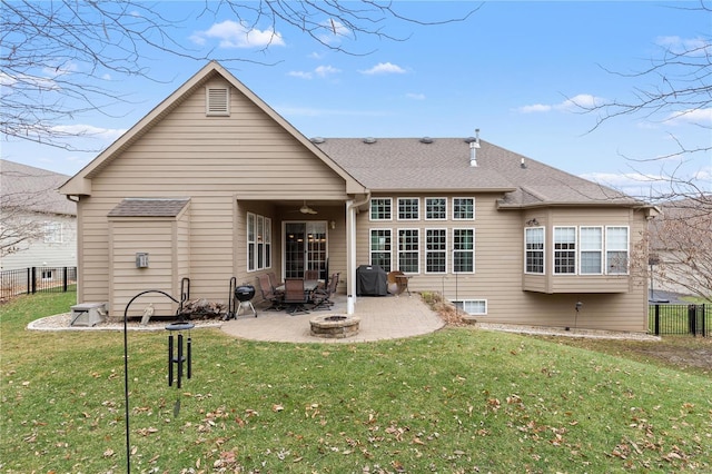 back of property with ceiling fan, a patio area, a fire pit, and a lawn