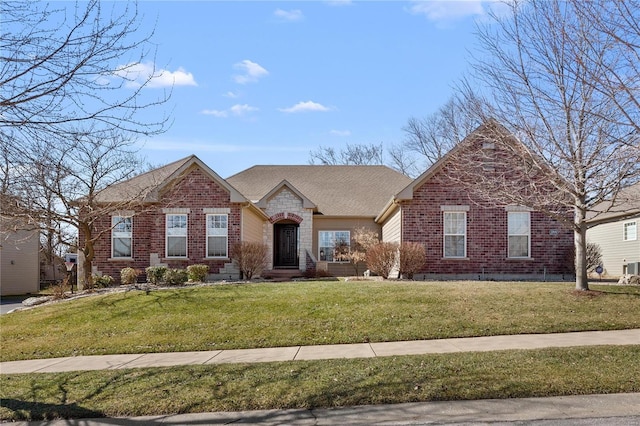 view of front of house featuring stone siding, brick siding, a front yard, and a shingled roof