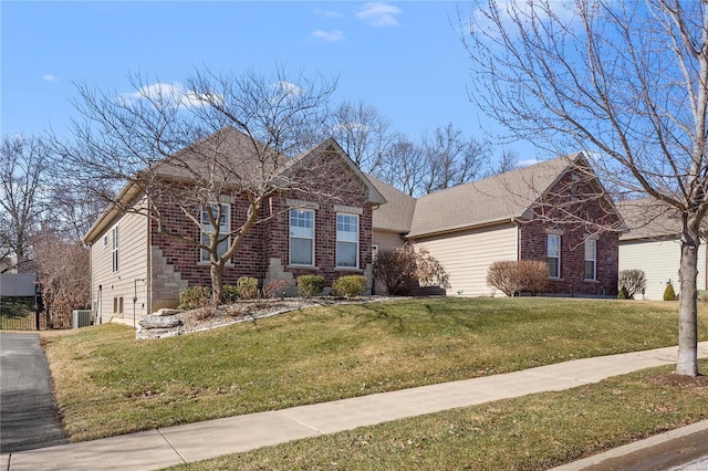 view of front of property featuring brick siding, a front lawn, and cooling unit