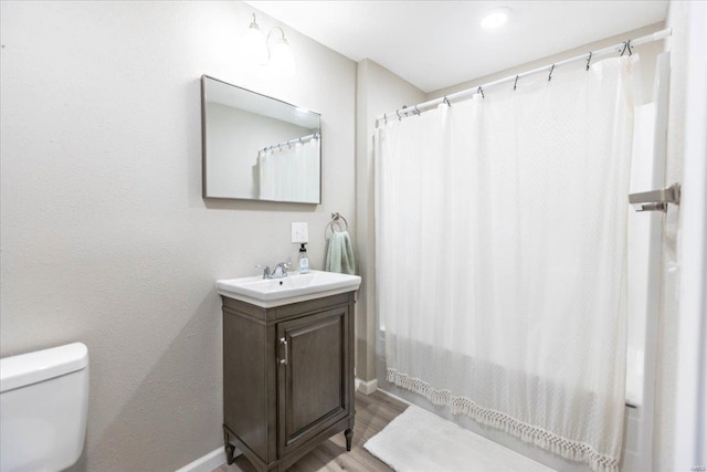 bathroom with a shower with shower curtain, vanity, toilet, and hardwood / wood-style floors