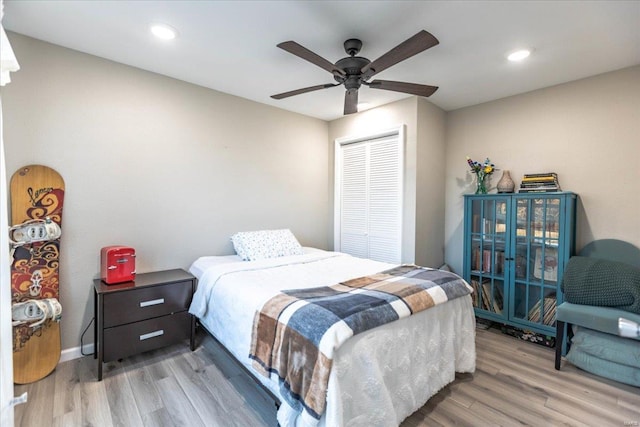 bedroom featuring ceiling fan, light hardwood / wood-style floors, and a closet