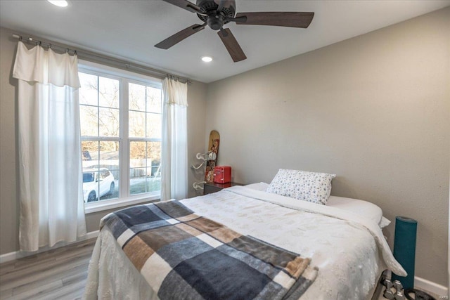 bedroom with multiple windows, hardwood / wood-style floors, and ceiling fan