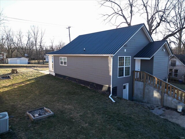 view of side of home featuring a garage, a yard, and central air condition unit