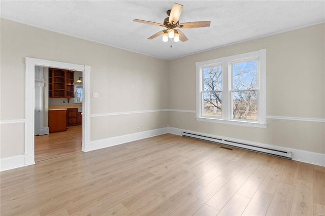 spare room with a baseboard heating unit, light hardwood / wood-style floors, and ceiling fan