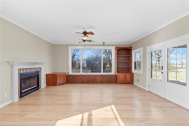 unfurnished living room featuring ornamental molding, ceiling fan, and light wood-type flooring