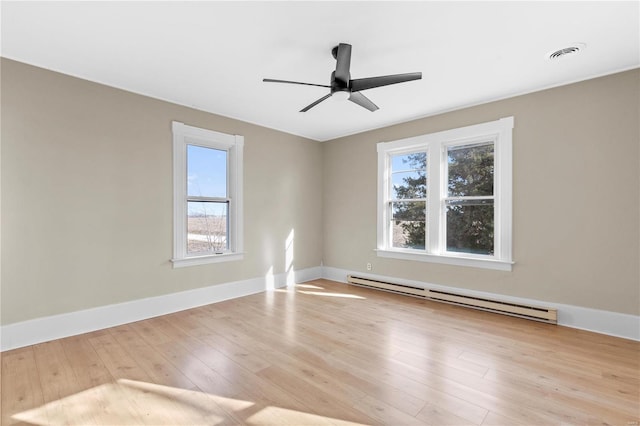 spare room with ceiling fan, baseboard heating, and light hardwood / wood-style floors