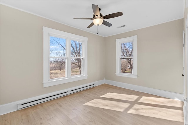 empty room featuring a baseboard heating unit, ornamental molding, ceiling fan, and light wood-type flooring