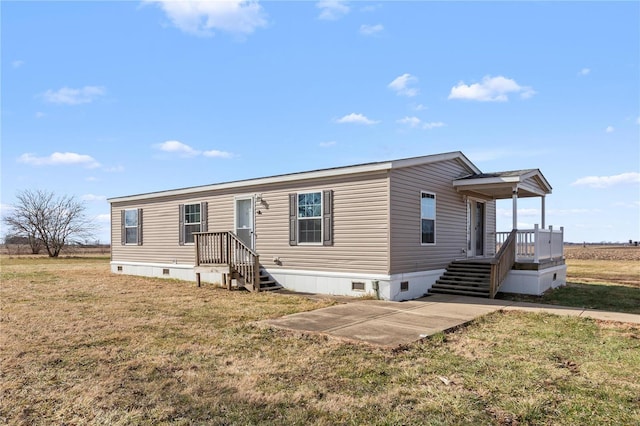 manufactured / mobile home featuring a front yard and a patio