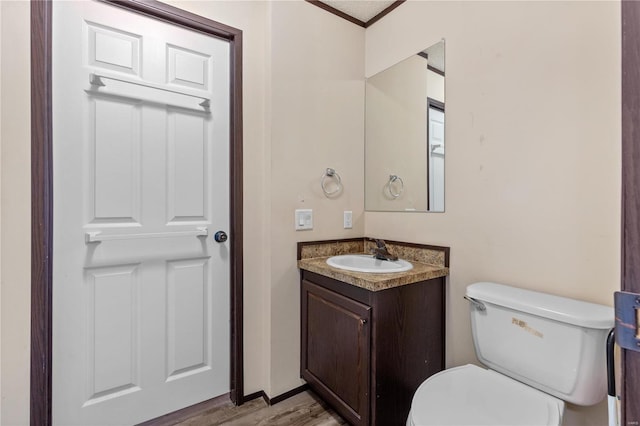 bathroom with vanity, toilet, and wood-type flooring