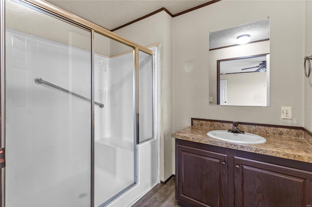 bathroom featuring wood-type flooring, a shower with door, a textured ceiling, and vanity