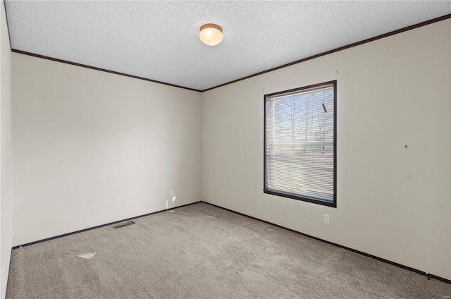 carpeted spare room featuring crown molding and a textured ceiling