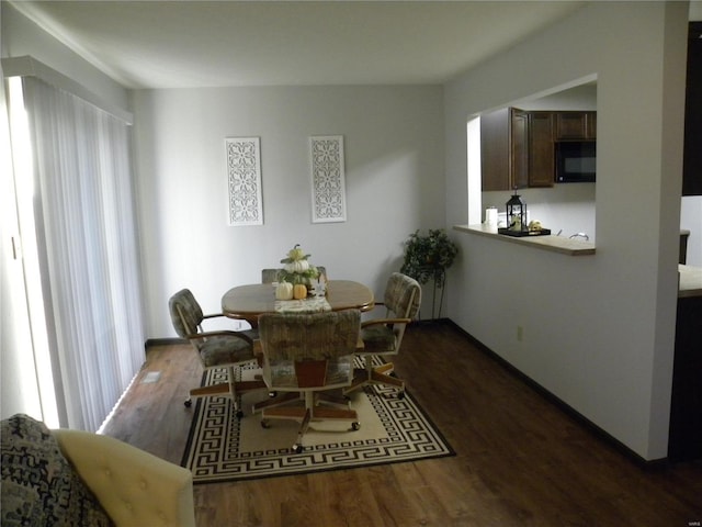 dining space with dark hardwood / wood-style flooring