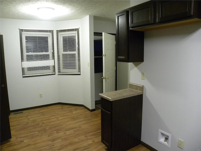 kitchen featuring hardwood / wood-style floors, dark brown cabinets, and a textured ceiling