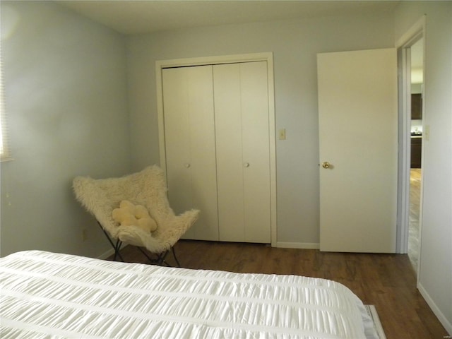 bedroom with dark wood-type flooring and a closet