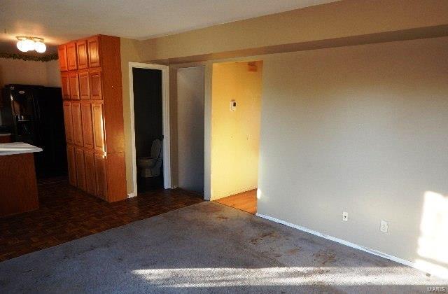 kitchen featuring parquet floors and black fridge