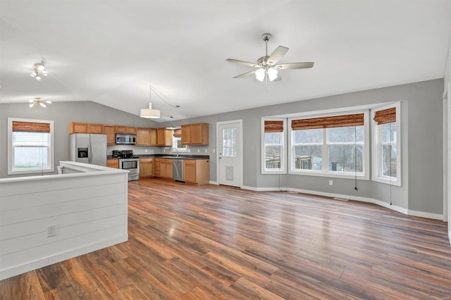 kitchen featuring lofted ceiling, sink, stainless steel appliances, dark hardwood / wood-style flooring, and decorative light fixtures