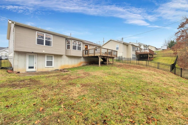 back of property with a wooden deck and a yard