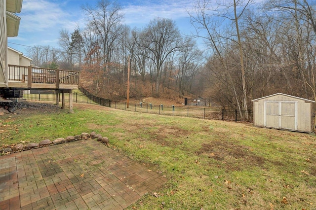 view of yard with a wooden deck, a patio area, and a storage unit