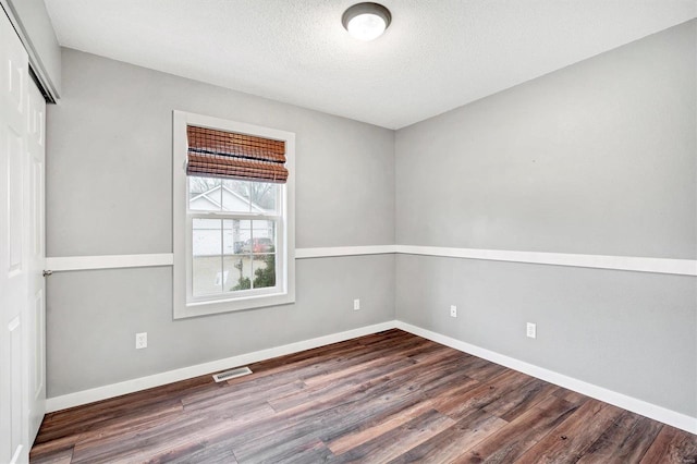 spare room with wood-type flooring and a textured ceiling