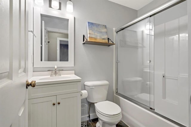 full bathroom featuring vanity, combined bath / shower with glass door, and toilet