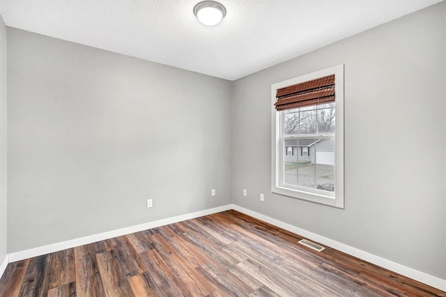 spare room with hardwood / wood-style floors and a textured ceiling