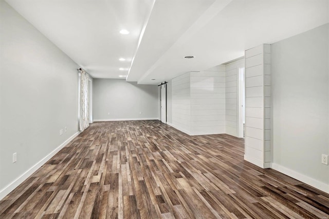 basement featuring hardwood / wood-style flooring and a barn door