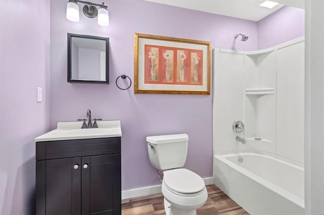 full bathroom with hardwood / wood-style flooring, vanity, washtub / shower combination, and toilet