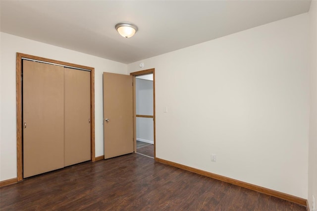 unfurnished bedroom featuring dark hardwood / wood-style floors and a closet