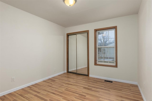 unfurnished bedroom with light hardwood / wood-style floors and a closet