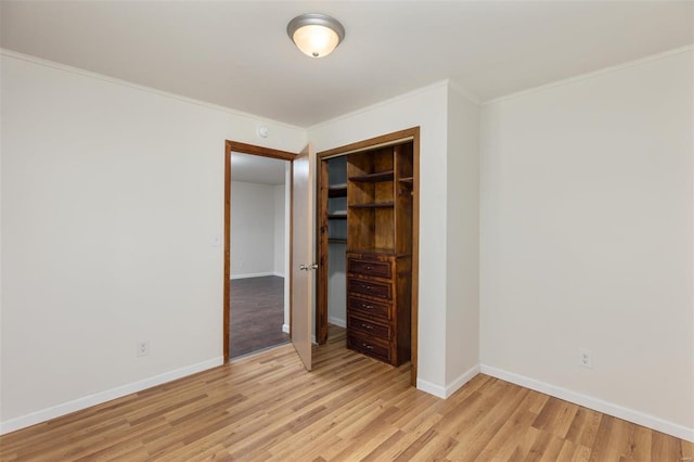 unfurnished bedroom with ornamental molding, light hardwood / wood-style floors, and a closet