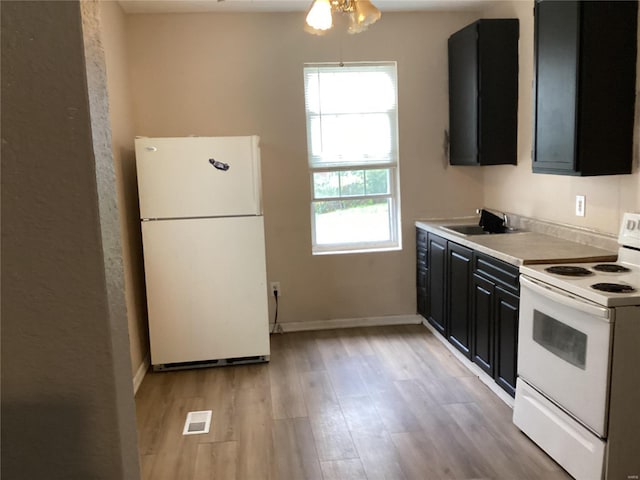 kitchen featuring white appliances, sink, and light wood-type flooring