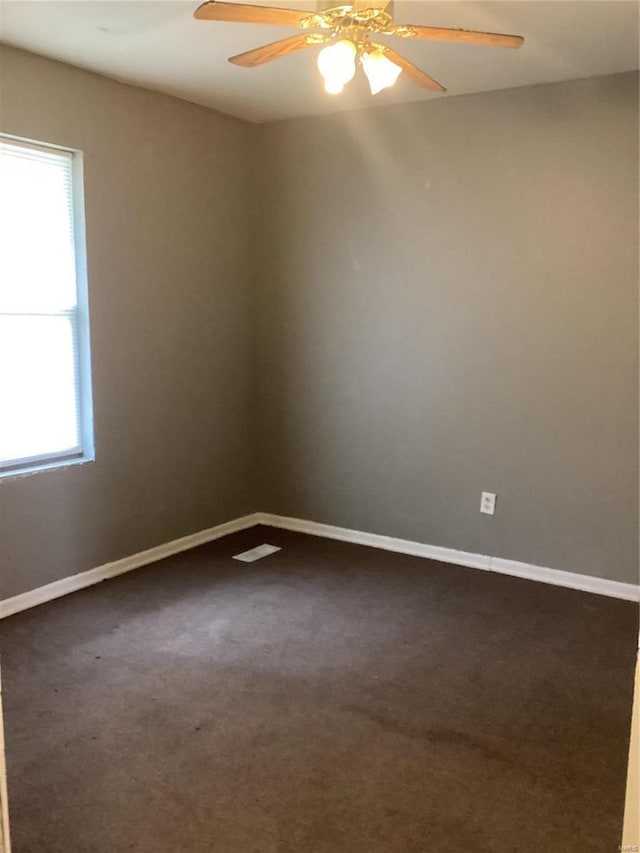 carpeted empty room featuring a wealth of natural light and ceiling fan