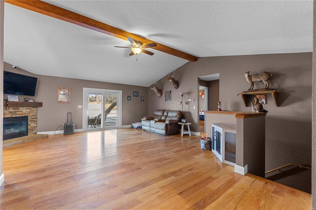 living room featuring a textured ceiling, a fireplace, and light hardwood / wood-style floors